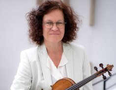 Bettina Hanschel-Lüdemann Zeigt Bettina Hanschel-Lüdemann lächelnd in die Kamera mit der Violine in der Hand