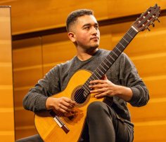 Pooya Mirzaee Foto von Pooya Mirzaee auf der Bühne mit der Gitarre in der Hand